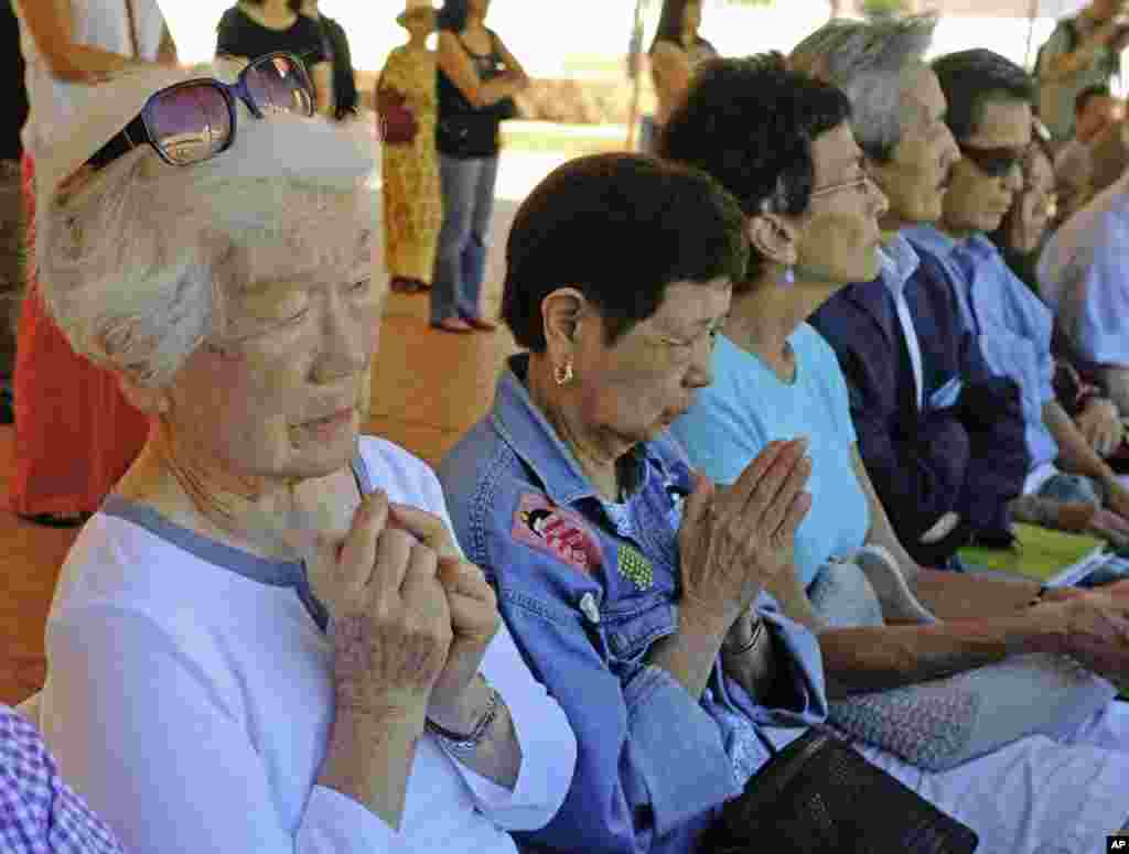 90 yoshli Kiyome Hirayama (chapda) Xirosima qurbonlari xotirasiga ibodat qilmoqda. Uning eri bomba portlagan payt Xirosima shahrida harbiy xizmatda edi.