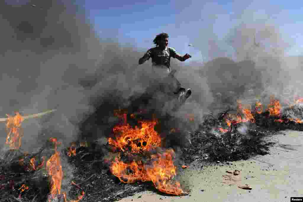 Members of the Homeless Workers&#39; Movement (MTST) protest against the Confederations Cup being held in Brazil, amidst burning tires in front of the National Mane Garrincha Stadium in Brasilia. Japan will play the opening match of the tournament against Brazil on June 15.