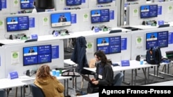 People sit inside the media room inside the Scottish Event Campus (SEC) in Glasgow, Scotland on Oct. 31, 2021, the venue of the COP26 UN Climate Change Conference. 