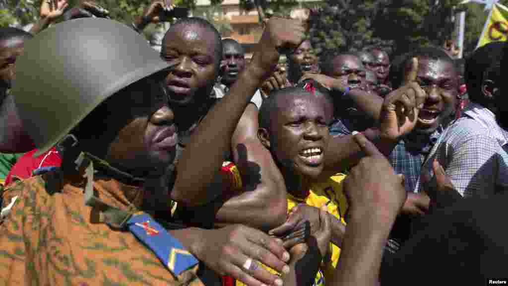 Wapinzani wa serikali wakiimba kwa furaha mbele ya makao makuu ya jeshi mjini Ouagadougou, Burkina Faso, Oct. 31, 2014. 