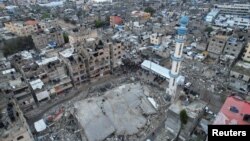 Rakyat Palestina melaksanakan salat Eid di sekitar puing-puing masjid al-Farouk di tengah konflik antara Israel dan kelompok Islamis Palestina Hamas di Rafah, di bagian selatan Jalur Gaza, Rabu, 10 April 2024. (Foto: Shadi Tabatibi/Reuters)