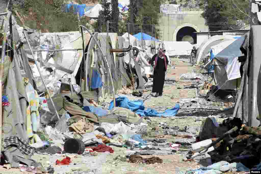 A woman inspects damage at a camp for internally displaced people after it was hit by what residents said was shelling carried out by forces allied with the government , near the Syrian-Turkish border in Jabal al-Turkman, Latakia province, Syria, Jan. 31, 2016.
