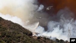 Helicopters drop fire retardant and water over the BlueCut fire in the Cajon Pass near San Bernardino, California, Aug. 17, 2016. 