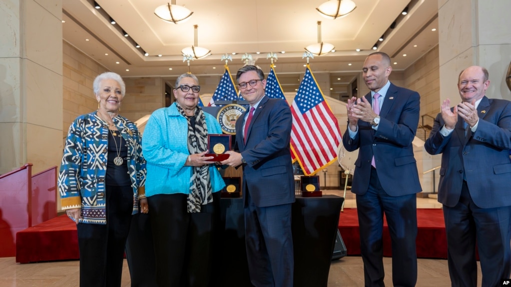 House Speaker Mike Johnson, center, presents a Congressional Gold Medal posthumously to Joylette Hylick, left, and Katherine Moore, daughters of Katherine Johnson at the Capitol in Washington, Sept. 18, 2024.