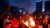 FILE - Protesters burn Myanmar flags during a demonstration against the military coup in Yangon on July 29, 2021. 