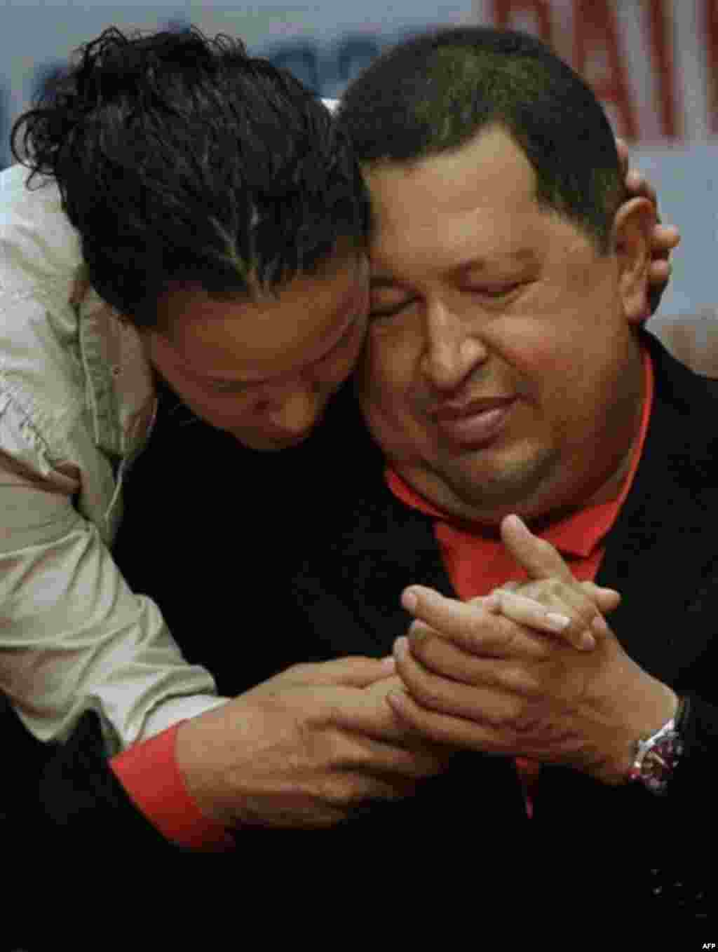 Venezuela's President Hugo Chavez, right, shares a moment with his daughter Rosa as he attends a concert in his honor at the Teresa Carreno theater in Caracas, Venezuela, Thursday, Feb. 23, 2012. Chavez is headed to Cuba for surgery Friday to remove a 