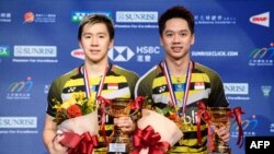 Marcus Fernando Gideon (kiri) dan Kevin Sanjaya Sukamuljo (kanan) merayakan kemenangan atas pasangan ganda Jepang, Keigo Sonoda dan Takeshi Kamura, dalam final ganda putra Hong Kong Terbuka, 18 November 2018.