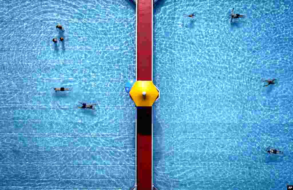 People swim in a public pool in Frankfurt, Germany.