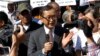 Opposition leader of Cambodia National Rescue Party Sam Rainsy, center, delivers a speech during a gathering to mark Human Rights Day, in front of National Assembly, in Phnom Penh, Cambodia, Wednesday, Dec. 10, 2014. (AP Photo/Heng Sinith)