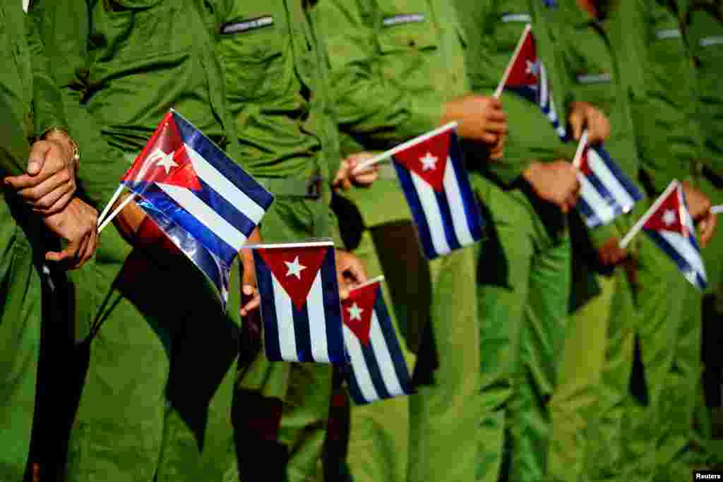 Army soldiers hold Cuban flags as they mark the 60th anniversary of the killing of Cuban revolutionary and student leader Jose Antonio Echeverria in Havana, March 13, 2017.