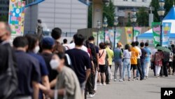 7일 한국 서울의 신종 코로나바이러스 감염 검사소에서 검사를 받기 위해 줄 선 시민들.