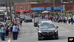 People line the street to pay respects as the hearse carrying the body of Rev. Billy Graham travels through Black Mountain, N.C., Feb. 24, 2018. The procession is part of more than a week of mourning that culminates with his burial next week at his library in Charlotte. 