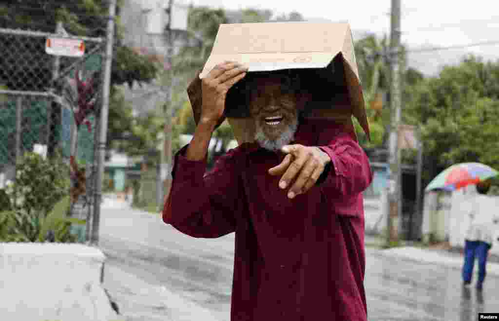 A man uses a box to protect him from the rain before the arrival of Tropical Storm Sandy in Kingston, Jamaica, October 23, 2012. 