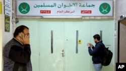 A man photographs the main entrance of the original Muslim Brotherhood office, that is sealed with official wax after it was raided and shut down by police, in Amman, Jordan, April 13, 2016. 