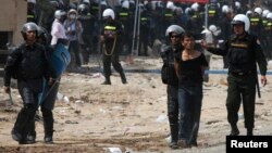 A protester is detained during clashes between garment workers and security forces in Phnom Penh nearly a year ago, on January 3, 2014.