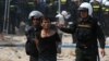 A protester is detained during clashes between garment workers and security forces in Phnom Penh a year ago, on January 3, 2014.