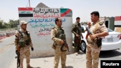 Members of the Kurdish security forces stand at a checkpoint during an intensive security deployment on the outskirts of Kirkuk June 11, 2014.