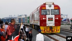 FILE - Kenyan President Uhuru Kenyatta watches a cargo train carrying port containers begin its opening run from Mombasa to Nairobi, Kenya, May 30, 2017. The project was financed by China.