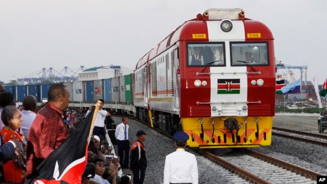 FILE - Kenyan President Uhuru Kenyatta watches a cargo train carrying port containers begin its opening run from Mombasa to Nairobi, Kenya, May 30, 2017. The project was financed by China.