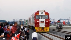 Kenyan President Uhuru Kenyatta, third from left, watches a cargo train carrying port containers begin its opening run from Mombasa to Nairobi, Kenya, May 30, 2017.