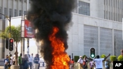 A protester burns vegetation in a street in Lilongwe, Malawi, Wednesday, July 20, 2011