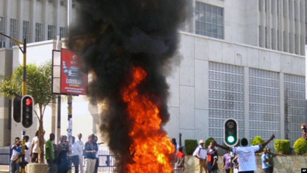 A protester burns vegetation in a street in Lilongwe, Malawi, Wednesday, July 20, 2011
