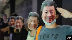 Protesters wear masks of Chinese President Xi Jinping in Hong Kong, Friday, Oct. 18, 2019. Hong Kong pro-democracy protesters are donning cartoon/superheroes masks as they formed a human chain across the semiautonomous Chinese city, in defiance of a government ban on face coverin