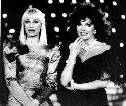 FILE - English actress Joan Collins, right, and Italian TV star Raffaella Carra record a new TV show in Milan, Italy, Jan. 23, 1988.