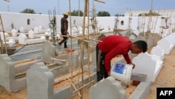 Des ouvriers construisent des tombes au "Jardin d'Afrique", un cimetière tunisien pour les migrants qui se sont noyés en traversant la Méditerranée dans l'espoir d'une vie meilleure en Europe, le 1er juin 2021 dans la ville portuaire de Zarzis.