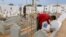 Des ouvriers construisent des tombes au "Jardin d'Afrique", un cimetière tunisien pour les migrants qui se sont noyés en traversant la Méditerranée dans l'espoir d'une vie meilleure en Europe, le 1er juin 2021 dans la ville portuaire de Zarzis.