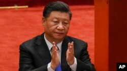 FILE - In this Oct. 9, 2021, photo, Chinese President Xi Jinping applauds during an event commemorating the 110th anniversary of Xinhai Revolution at the Great Hall of the People in Beijing. 