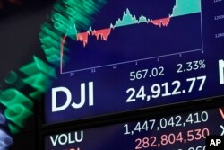 A board above on the trading floor of the New York Stock Exchange shows the closing number for the Dow Jones industrial average, Feb. 6, 2018.