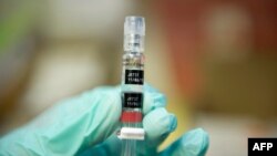 FILE - A nurse loads a syringe with a vaccine against hepatitis at a free immunization clinic for students before the start of the school year, in Lynwood, California, Aug. 27, 2013. 