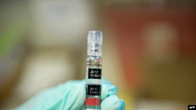 FILE - A nurse loads a syringe with a vaccine against hepatitis at a free immunization clinic for students before the start of the school year, in Lynwood, California, Aug. 27, 2013.