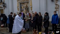 Fieles cristianos ortodoxos y sus canastas de Pascua tradicionales son bendecidos durante el Domingo de Pascua en el complejo monástico de Pechersk Lavra, Kiev, el domingo 16 de abril de 2023. (Foto AP/Bernat Armangue)