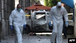 Dua petugas forensik Tunisia bekerja di lokasi serangan bunuh diri di Tunis, Kamis (27/6). 