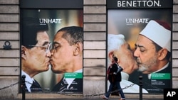 A Benetton clothing store window in Paris is covered by posters showing Pope Benedict XVI kissing Egypt's Ahmed el Tayyeb and US president Barack Obama kissing his China's Hu Jintao, November 17, 2011.