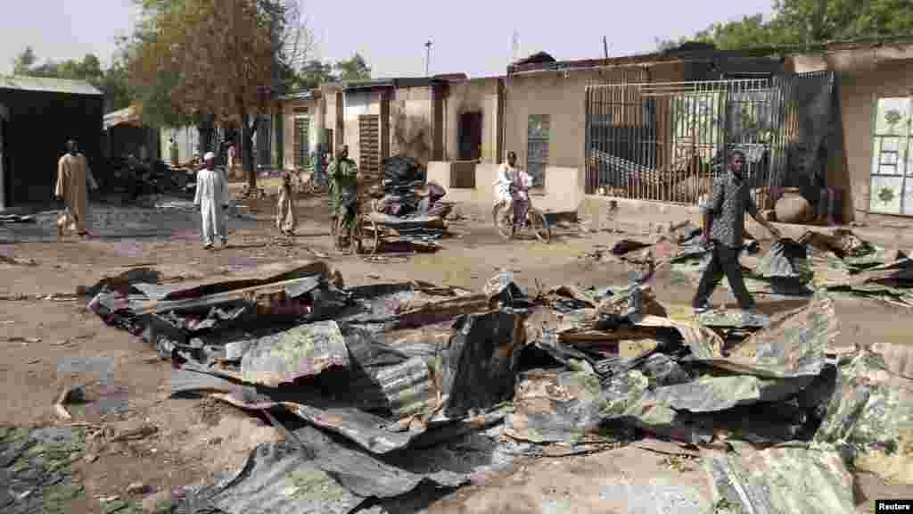 People walk through the burnt ruins of Bama Market, which was destroyed by gunmen in last Thursday's attack, in Maiduguri, northeast Nigeria April 29, 2013.
