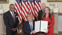 U.S. President Donald Trump, next to Jon Ponder and his wife, and former FBI agent Richard Beasley, shows a signed document after he announced that he is pardoning Ponder, during the largely virtual 2020 Republican National Convention.