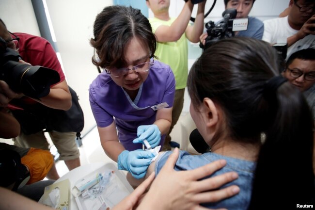 A woman from Beijing receives an injection of the HPV vaccine at a hospital in Boao, Hainan province, China, May 30, 2018.