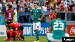 German midfielder Mesut Ozil, center, reacts after a 2-0 loss to South Korea that eliminated Germany from the World Cup, June 27, 2018, in Kazan Arena in Kazan, Russia.
