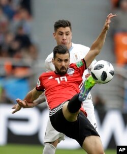 Egypt's Abdalla Said, foreground, challenges for the ball with Uruguay's Jose Gimenez during Uruguay's 1-0 victory in a group A match in the Yekaterinburg Arena in Yekaterinburg, Russia, June 15, 2018.