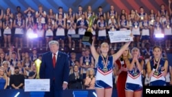 Президент США Дональд Трамп на сцене вместе со спортсменами во время финала соревнований «Патриотические игры» 2026 года в академии SPIRE в городе Дженива, штат Огайо, 11 августа 2026 года.
