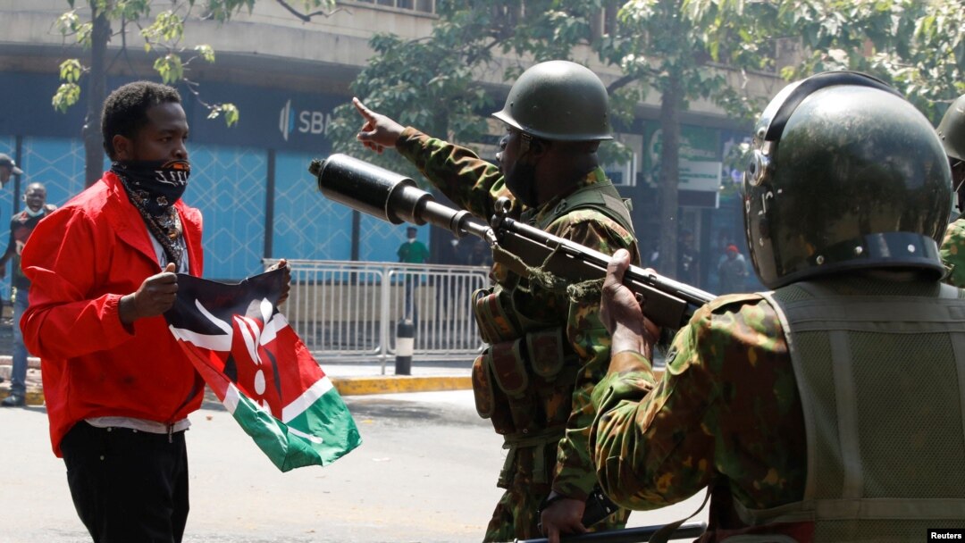 Demonstrant ispred policajaca u Najrobiju (REUTERS/Monicah Mwangi)