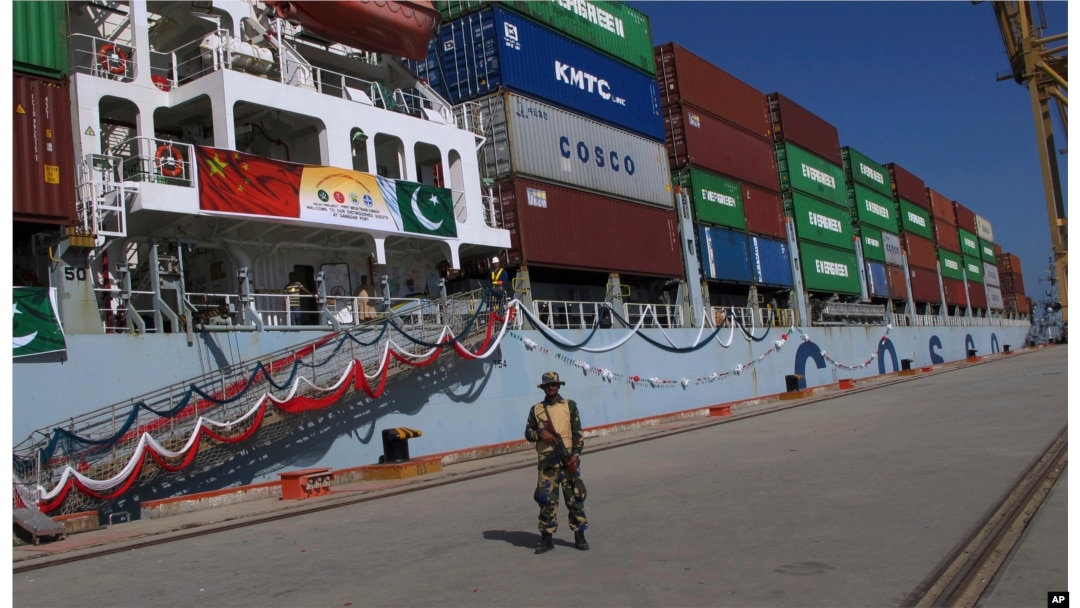 FILE - A Pakistan soldier stands guard while a loaded Chinese ship prepares to depart Gwadar port, about 700 kilometers (435 miles) west of Karachi, Pakistan, Nov. 13, 2016.