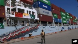 A Pakistan soldier stands guard while a loaded Chinese ship prepares to depart Gwadar port, about 700 kilometers (435 miles) west of Karachi. Pakistan, Nov. 13, 2016.