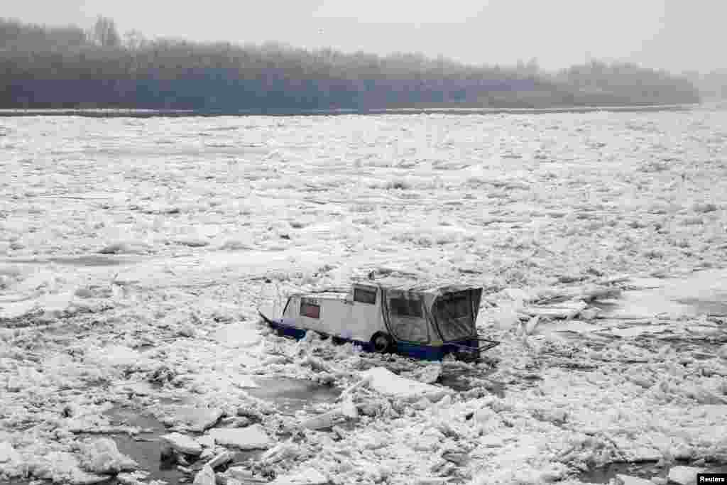A small boat trapped in the frozen Danube river is seen in Belgrade, Serbia.
