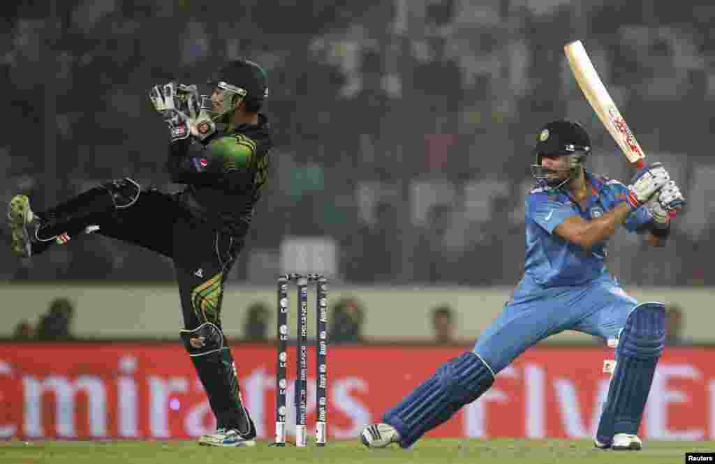 پاکستانی وکٹ کیپر کامران اکمل بھارتی کھلاڑی ورات کوہلی کی طرف سے کھیلی گئ گیند کو پکڑنے کی کوشش کرتے ہوئے