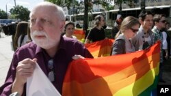 Un homme tient un drapeau lors de la première gay pride de l'Ukraine à Kiev, le 25 mai 2013. 