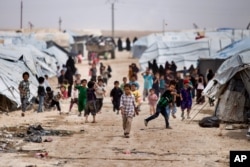 FILE - Children gather outside their tents at al-Hol camp, which houses families of members of the Islamic State group, in Hasakeh province, Syria, May 1, 2021.